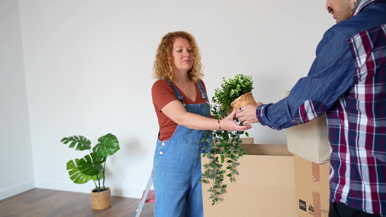 Couple Unpacking Potted Plants in Their New Home