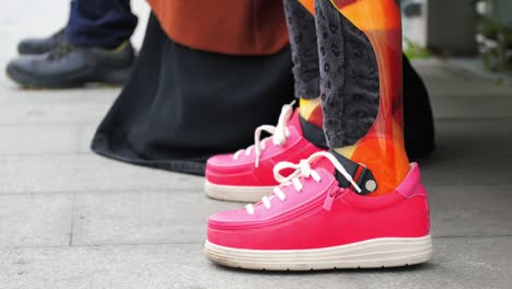 person with prosthetic leg wearing pink shoes