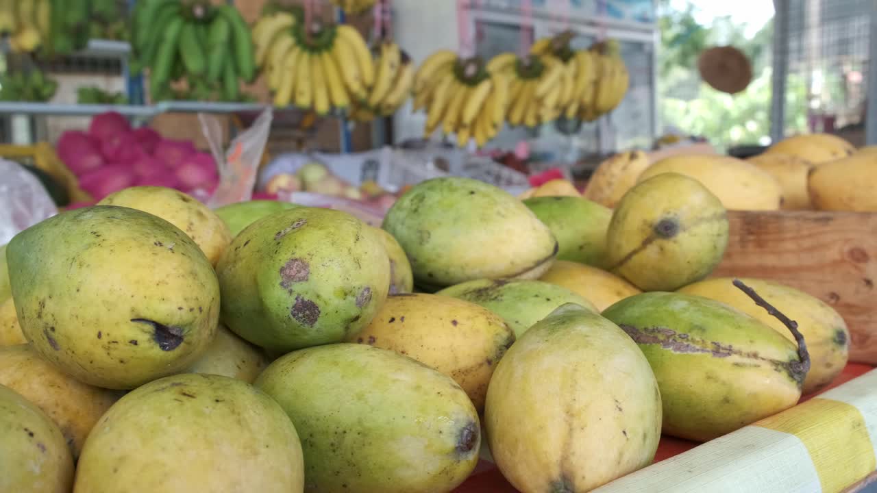 fruta fresca en un puesto de mercado con cerca de mangos tailandeses con sartén lento de izquierda a derecha en tailandia