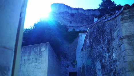 Disparó-A-Través-De-Una-Bonita-Ventana-En-Una-Pequeña-Ciudad-Histórica-Tranquila-Bajo-El-Sol-Con-Una-Ruina-De-Piedra-Histórica