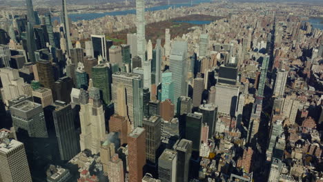 High-angle-view-of-high-rise-office-and-apartment-buildings-in-midtown.-Tilt-up-reveal-of-Central-park-and-surrounding-boroughs.-Manhattan,-New-York-City,-USA