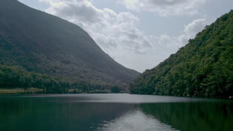 un lago tranquilo se encuentra frente a dos montañas tranquilas mientras la cámara se inclina lentamente hacia el agua