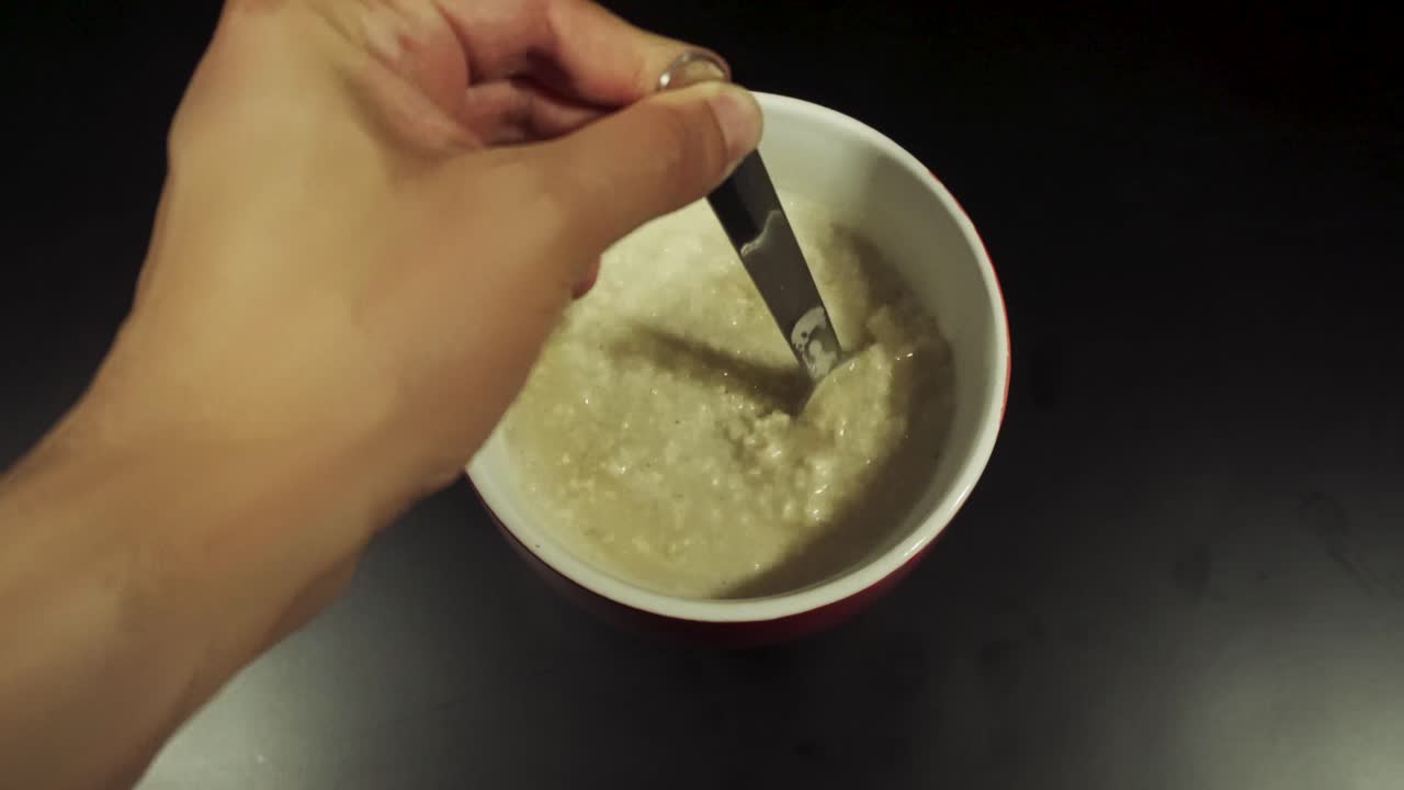 오트밀이 빨간 그릇에 휘젓고 있다