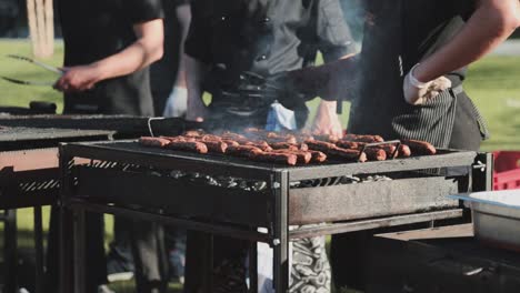 a man baking some meats on the heavily glowing grid and rotate them