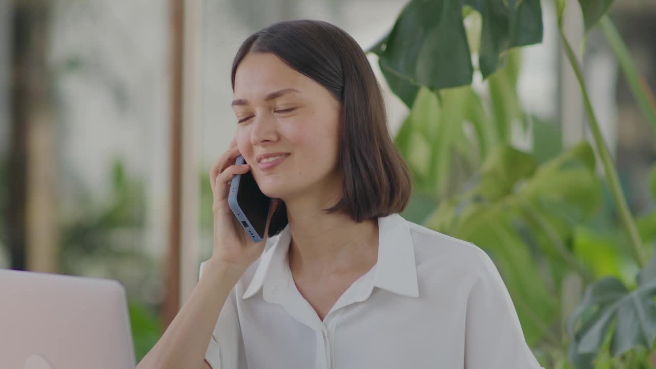Businesswoman Speaking on Phone in Outdoor Cafe