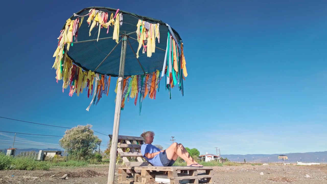 Donna in vacanza economica si rilassa in spiaggia in un resort turistico fatiscente.