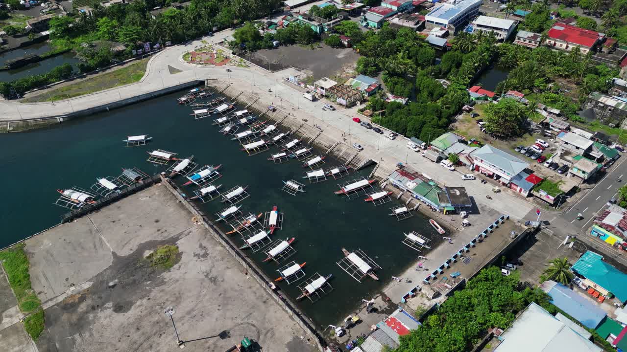 Aerial pullback of pier full of traditional bangka fishing vessels at Tabaco, Albay, Philippines.