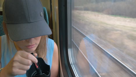 young woman taking a photo on train