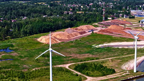 aerial view of renewable energy wind turbines and wood processing site near baltic sea