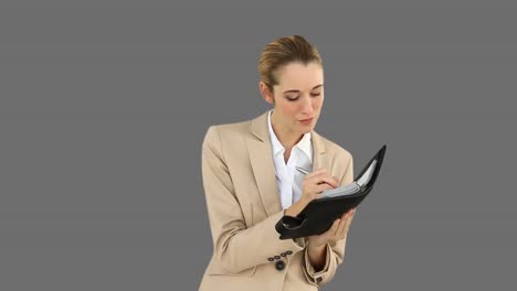 mujer de negocios escribiendo en su diario