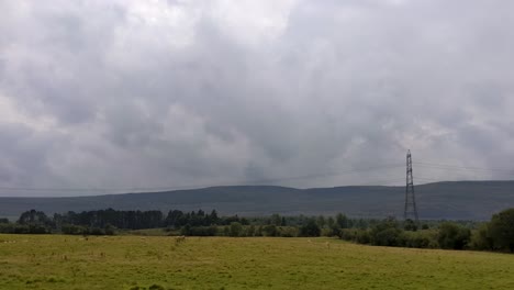 toma panorámica de ovejas pastando en un campo con postes de electricidad y fondo de paisaje de montaña espectacular en brecon beacons gales reino unido 4k