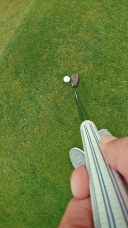 POV-golfer-hitting-golf-ball-chip-shot-with-iron-onto-green,-looking-down-club-top-down-view-on-iconic-Irish-links-golf-course