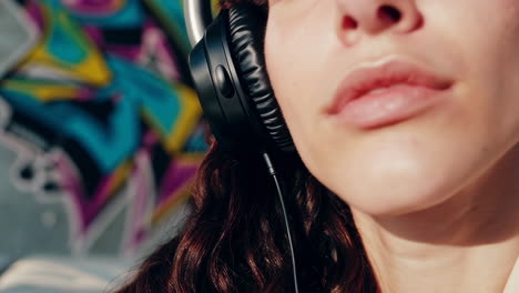 woman listening to music on a sofa with graffiti background