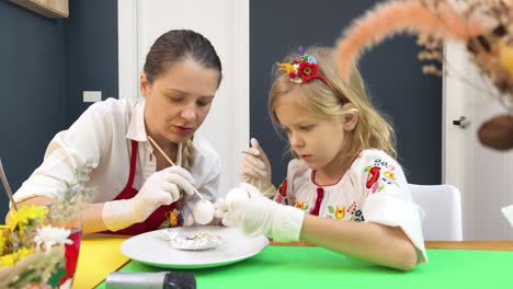 mother and daughter decorating easter eggs