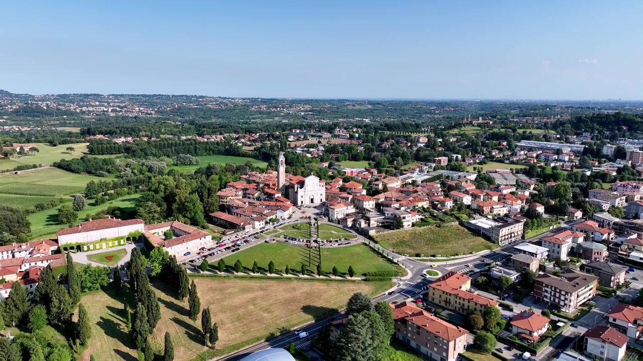 Veduta aerea diurna di Lurago d'Erba nella regione della Brianza, Lombardia, Italia. Mette in risalto l'architettura tradizionale del villaggio, la chiesa centrale e la campagna circostante.