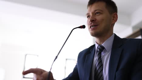 man speaking into a microphone at a conference or presentation