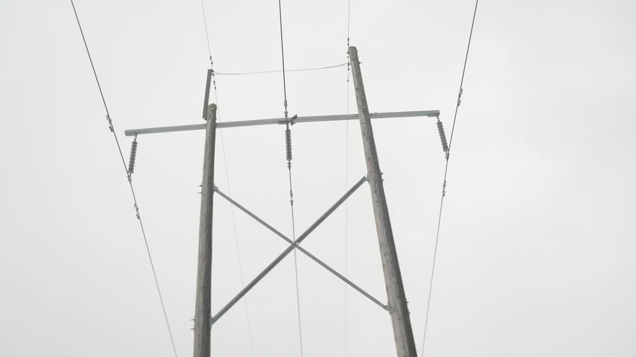 Tracking shot of a tall wooden hydro pole with 5 ines