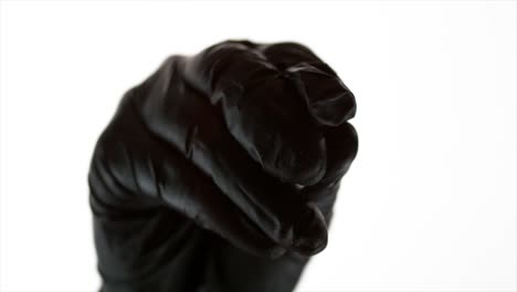 close up of hand with black glove sprinkling sea salt towards camera