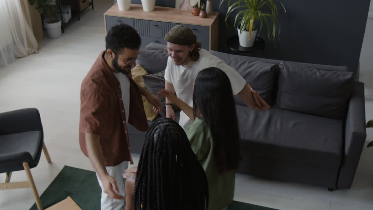Friends Greeting and Exchanging Gifts at a Social Gathering in a Living Room