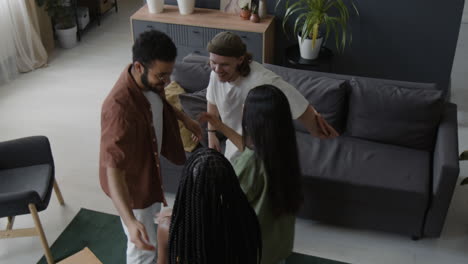 friends greeting and exchanging gifts at a social gathering in a living room