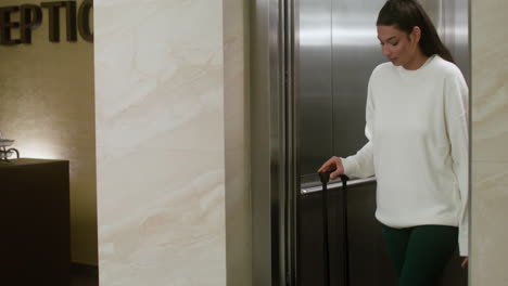 woman exiting the elevator in the hotel hall