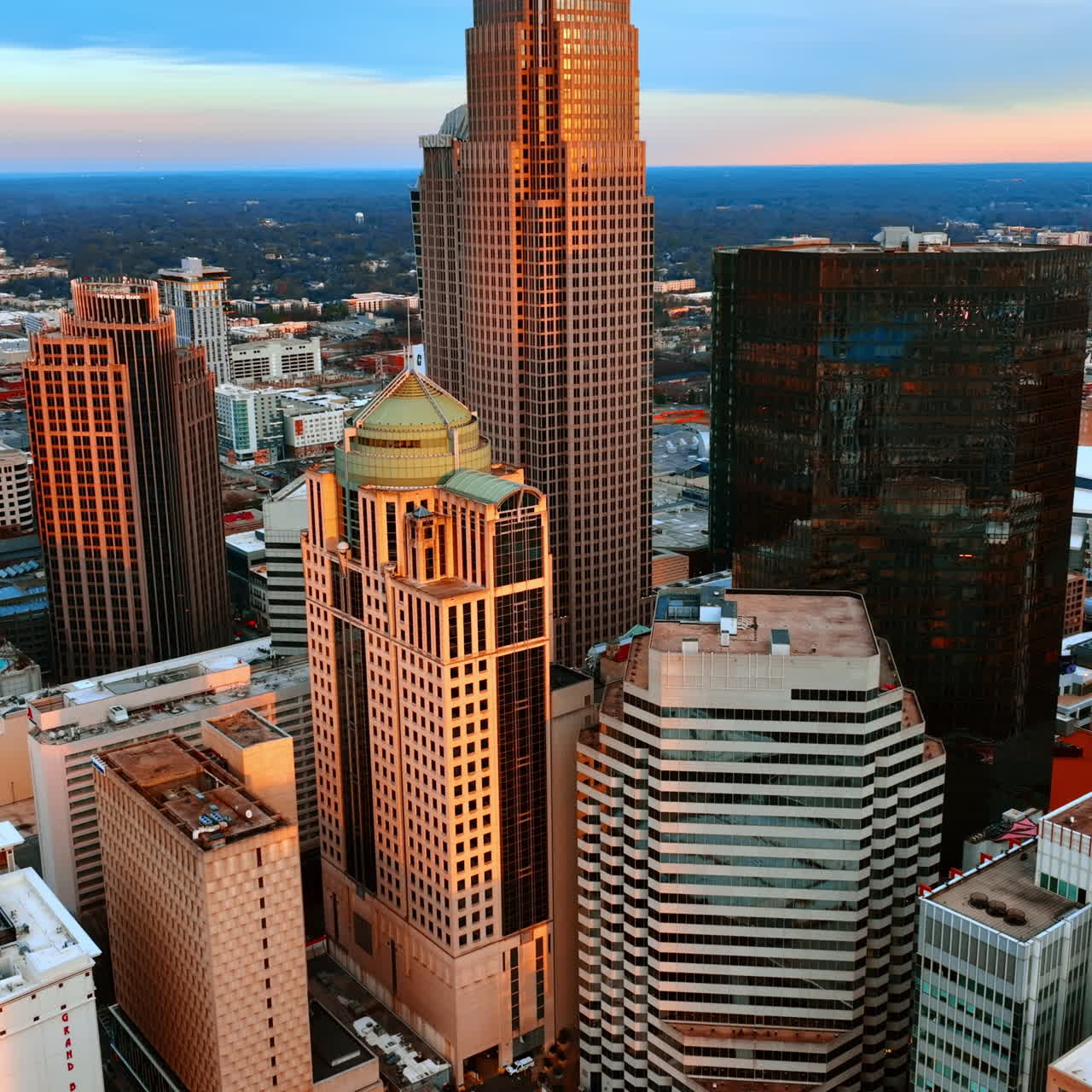 Luce arancione del tramonto sulle facciate dei grattacieli. Vista del centro di Charlotte, Stati Uniti dall'alto