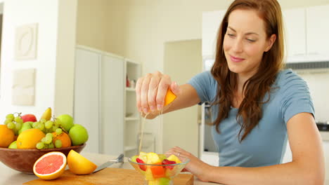 Mujer-Bonita-Preparando-Una-Ensalada-De-Frutas-Sonriendo-A-La-Cámara.