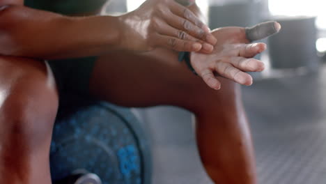 applying chalk on hands, woman preparing for weightlifting in gym, copy space