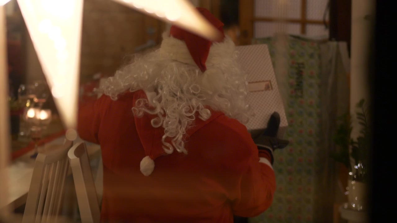 Inquadratura scorrevole a sinistra attraverso la finestra di Babbo Natale che distribuisce regali di Natale.