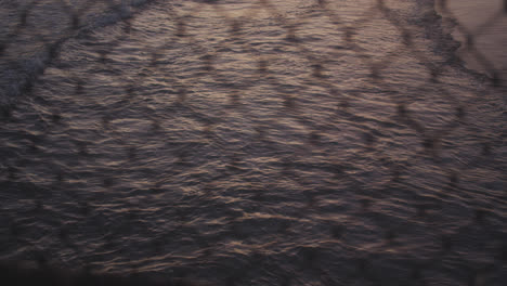 the pacific through a chainlink fence