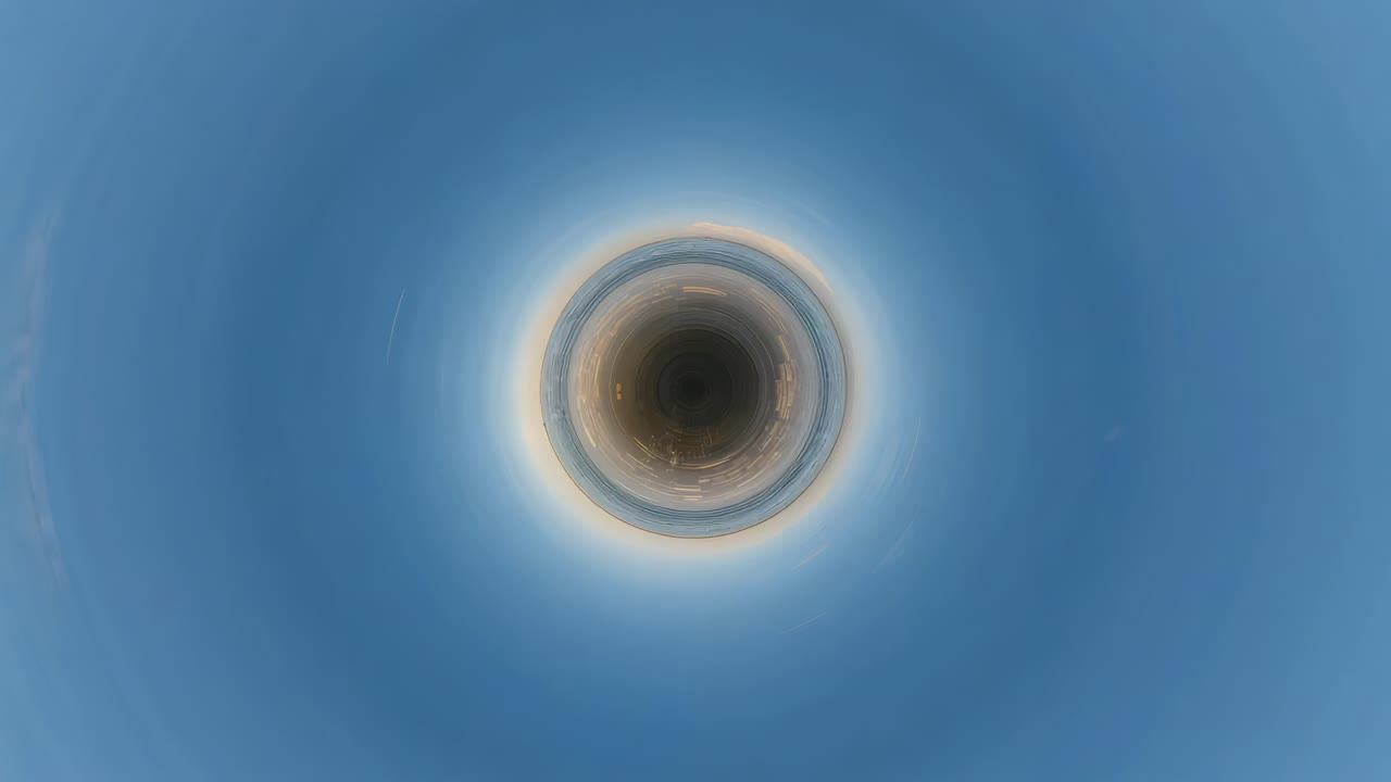 Expanding circular coast projection from dark core, forming ringed shore at sunrise showing glint