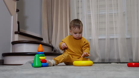 niño pequeño jugando con anillos apilados