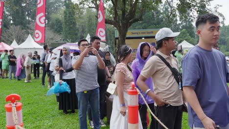 indonesian people queing at an outdoor music concert festival in bogor, west java, indonesia. orderly, organized, crowds.