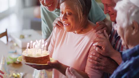 hombre caucásico mayor teniendo una feliz fiesta de cumpleaños y pastel con diversos amigos mayores, cámara lenta