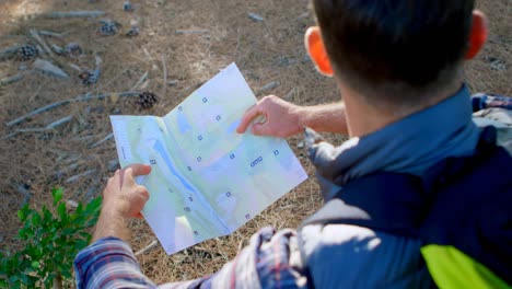 male hiker looking at map in the forest 4k