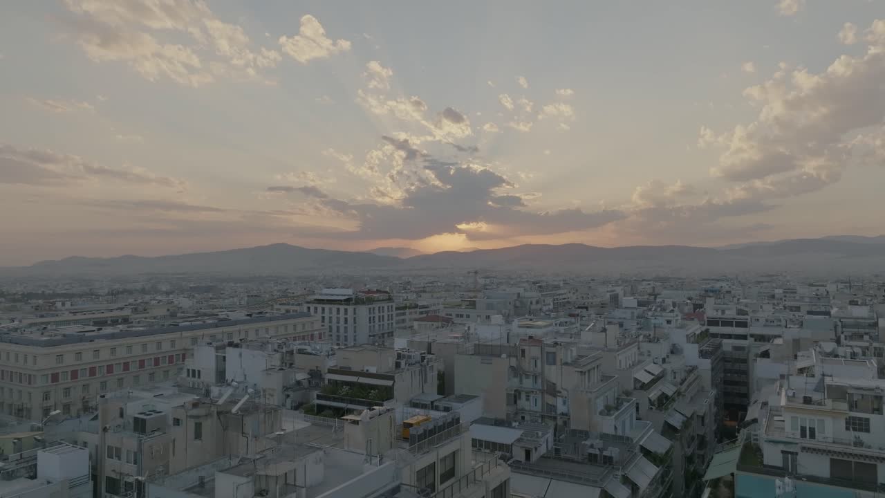 aéreo - vuelo bajo sobre edificios en atenas, grecia al atardecer