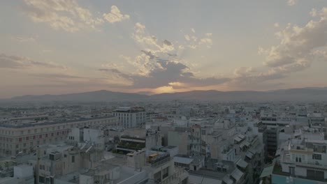 aerial - low flight over buildings in athens, greece at sunset