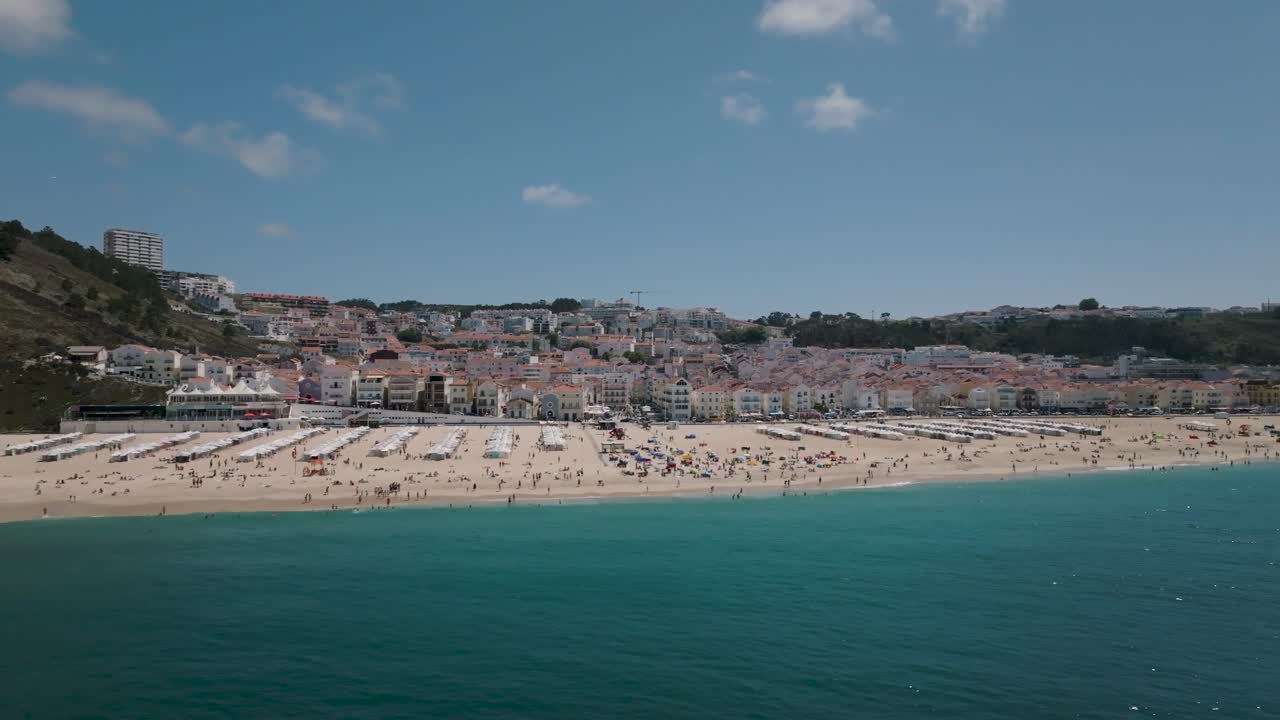Ripresa panoramica con drone della spiaggia di Nazaré dal mare con una bella vista della città