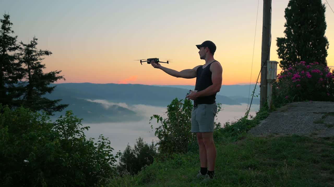 오래된 마을에서 촬영 된 믿을 수 없는 빛으로 해가 뜨면 드론을 시작하고 들어 올리는 남자 또는 모델