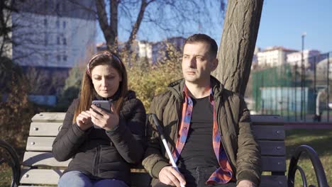 Blind-man-and-his-wife-sitting-on-a-park-bench.