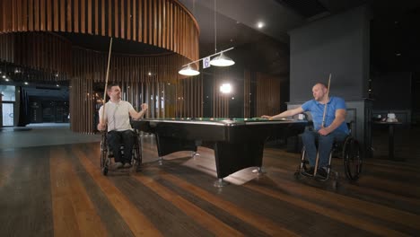 adult men with disabilities in a wheelchair play billiards in the club