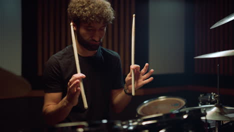 drummer sitting in concert hall. musician training fingers in recording studio.