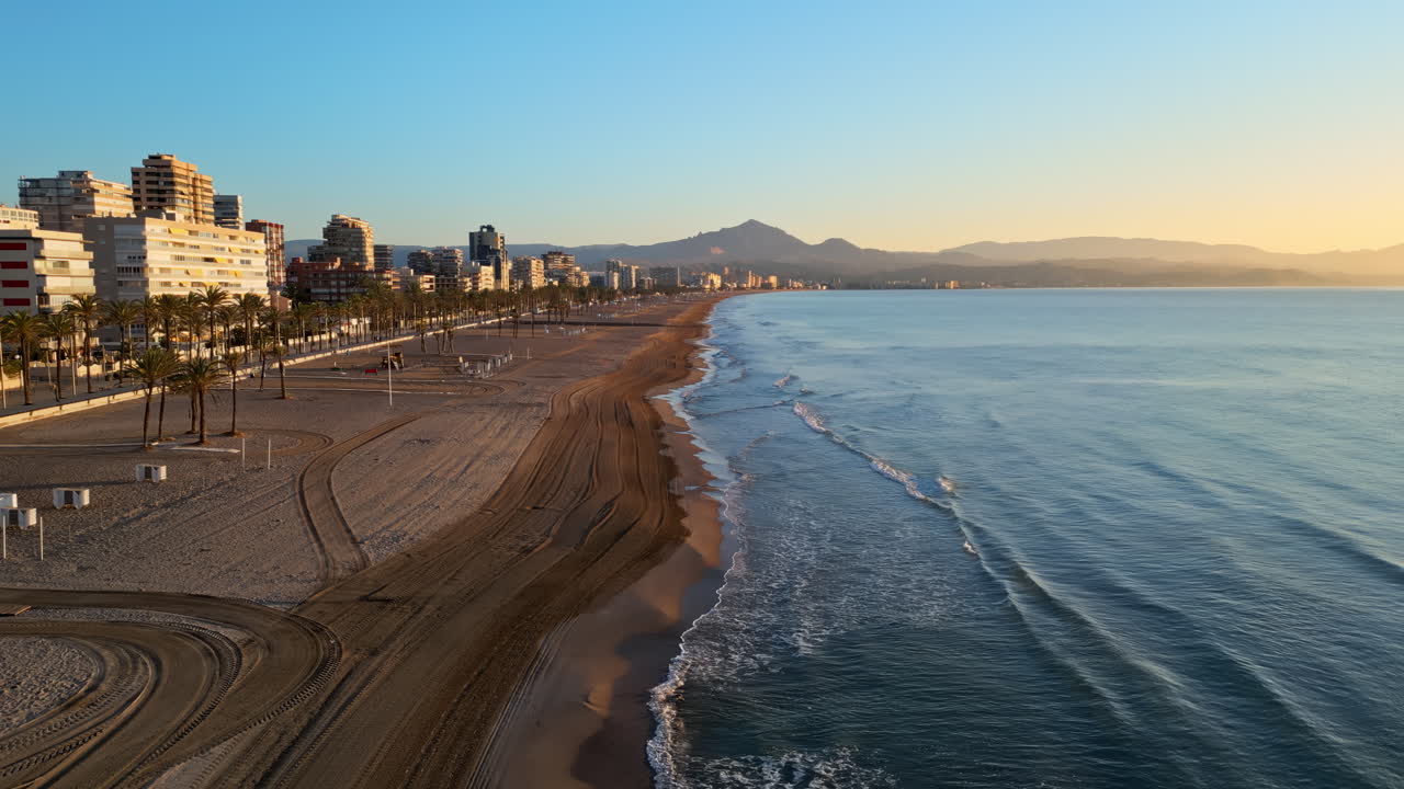 Aerial drone view of the Mediterranean Sea and the city of Alicante, Spain at sunset