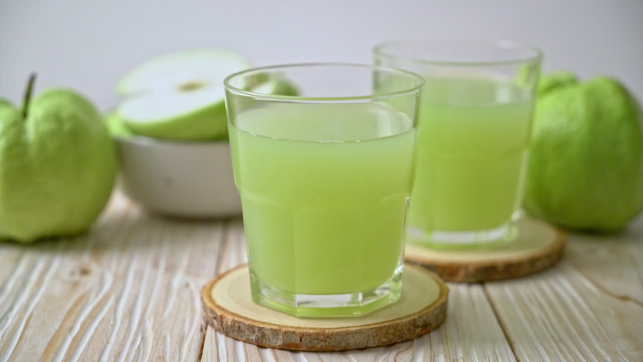 Vaso de jugo de guayaba fresca con fruta de guayaba fresca