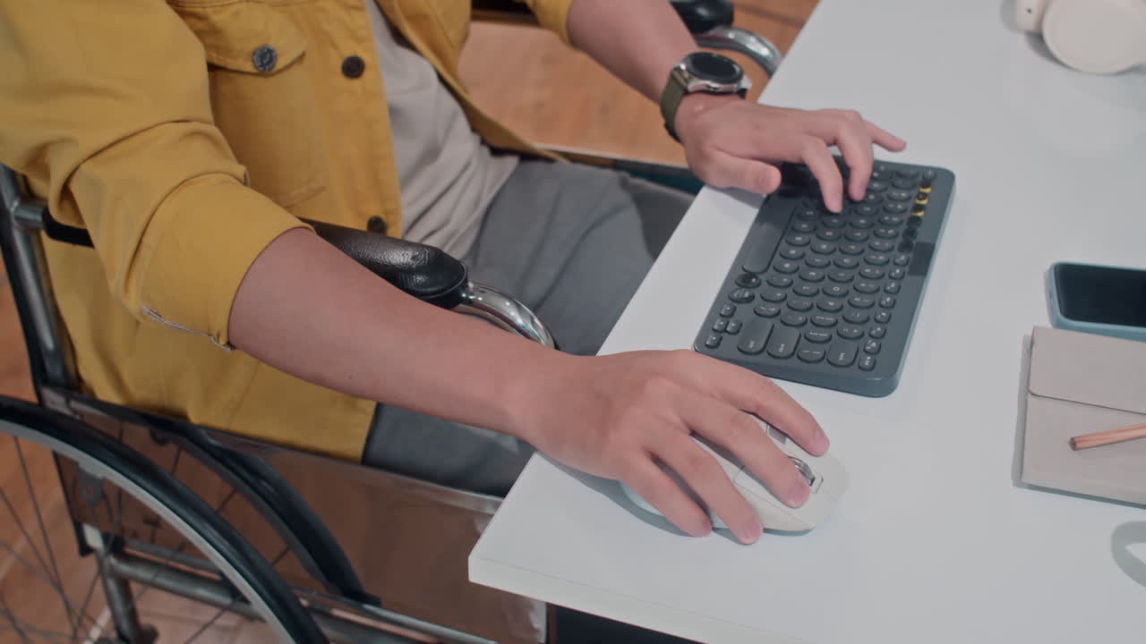 Unrecognizable Employee with Disability Using Computer at Office