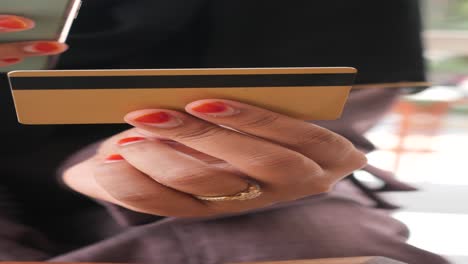 woman holding a credit card and phone, ready for online shopping