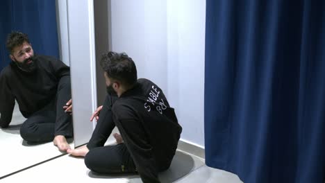 정신병을  ⁇ 고 있는 남자가 혼자 거울을 쳐다보고 있습니다.