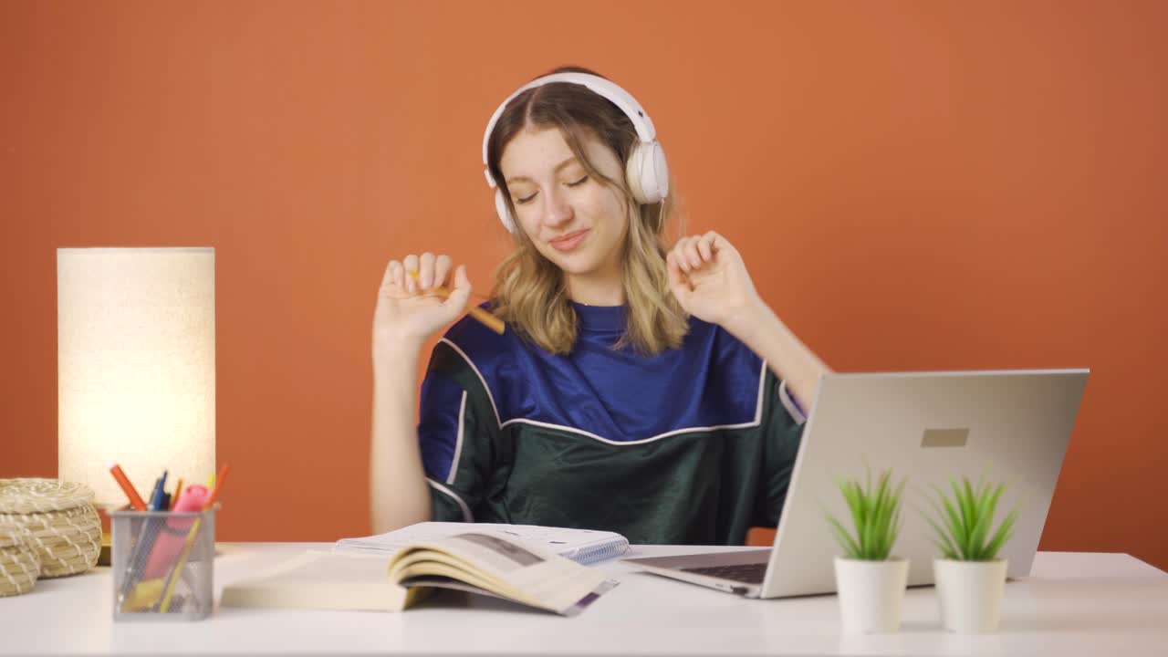 la joven que mira la computadora portátil está feliz y bailando.