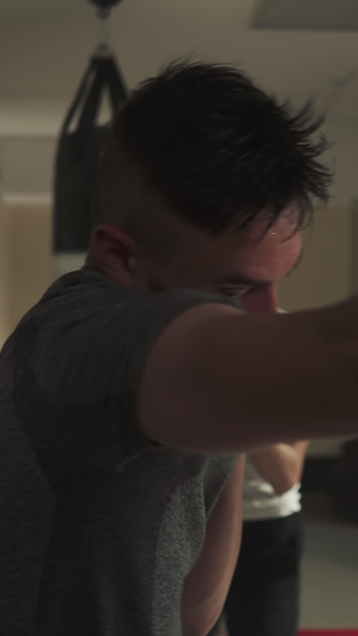grupo de boxeadores masculinos repiten el movimiento de puñetazo siguiendo al entrenador mientras practican el boxeo. construcción muscular a través de movimientos activos. instrucción del líder en el gimnasio