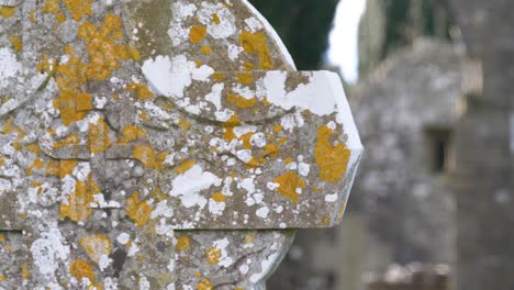 lichen-covered stone cross on the old cemetery near the cathedral of st